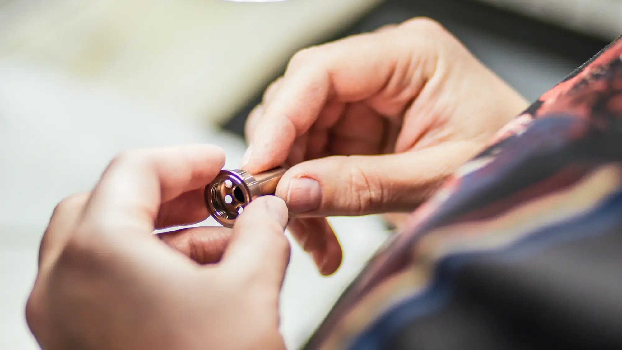 person-hands-inspecting-metal-component